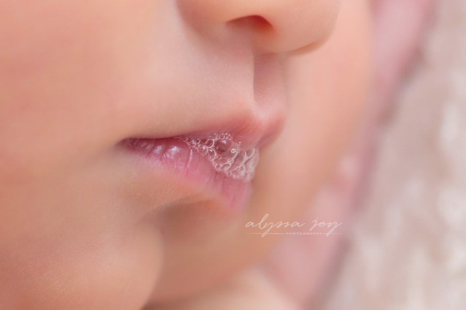 macro shot of newborn baby lips making little milk bubbles