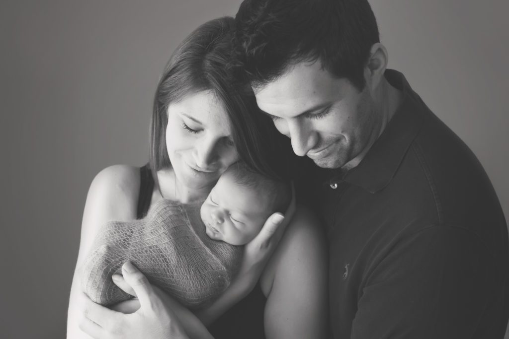 black and white image of new mom and dad holding their baby boy Alyssa Joy Photography