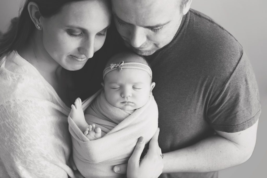 new mom and dad posing with newborn baby girl black and white