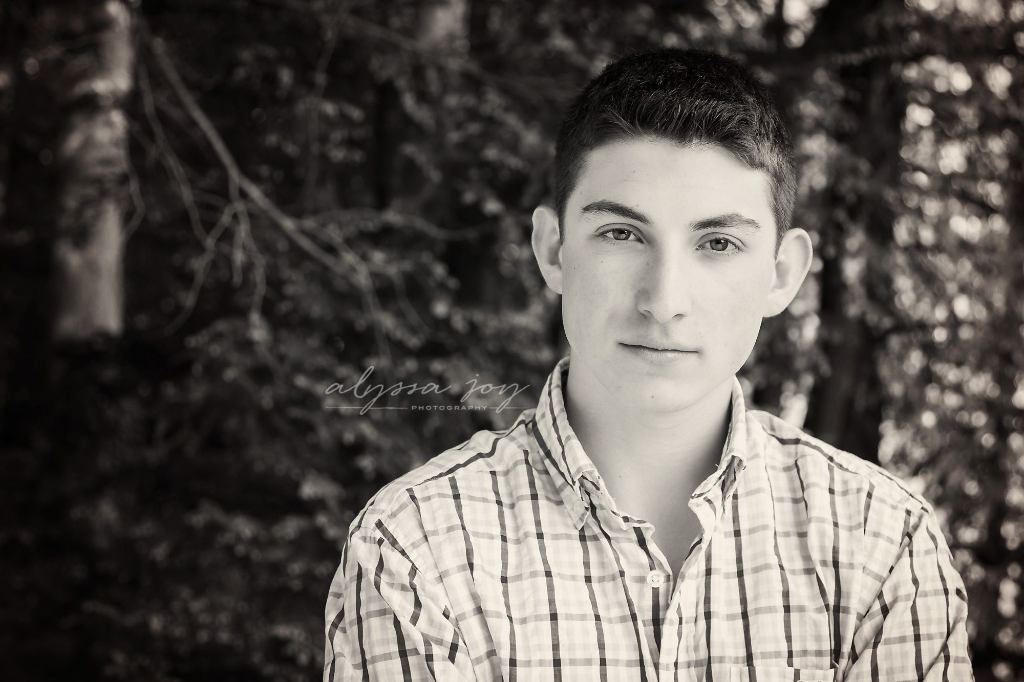 black and white photo of teenage boy in plaid shirt 