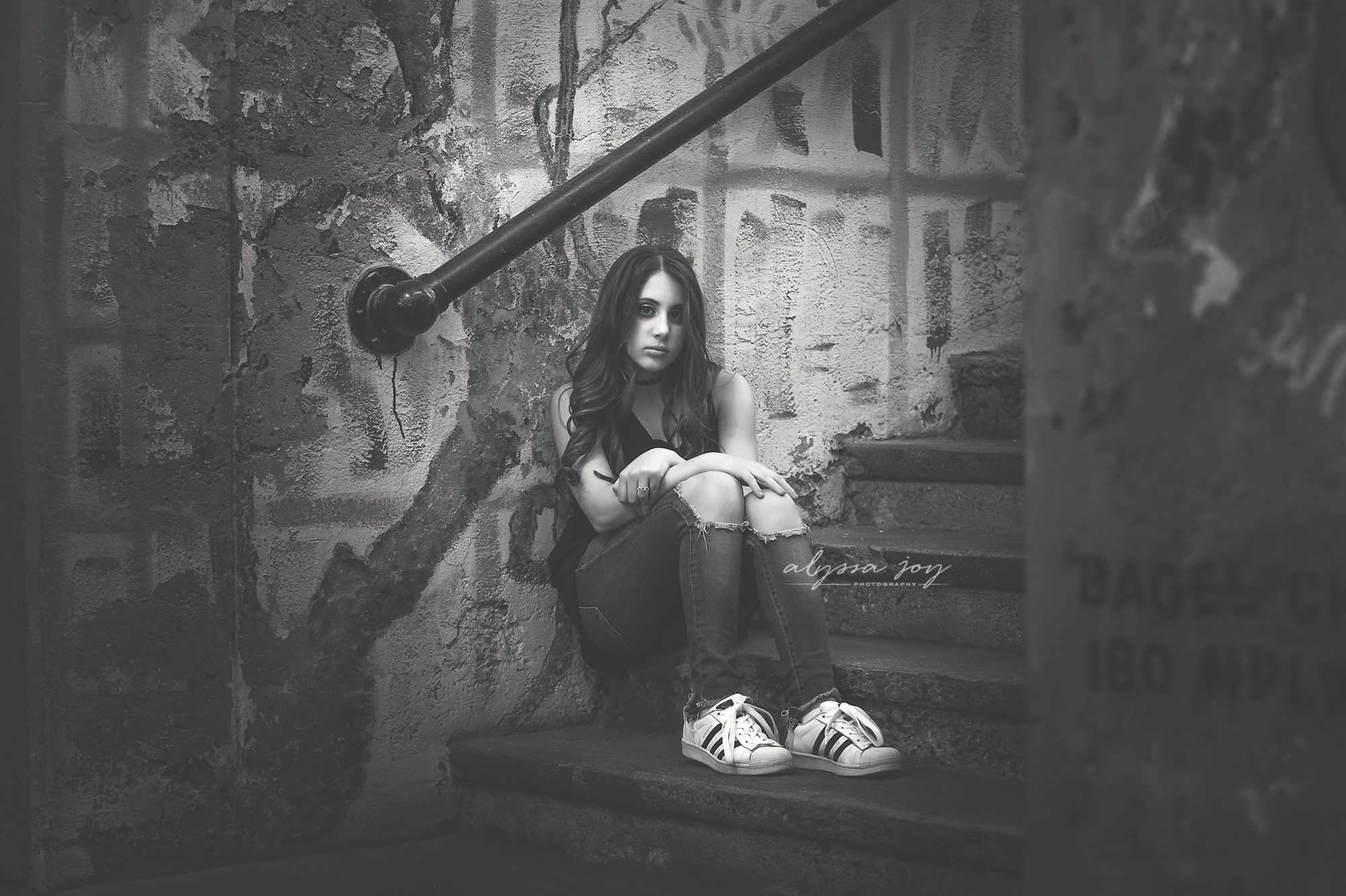 urban shot of teenage girl sitting on steps in front of graffiti wall Alyssa Joy Photography