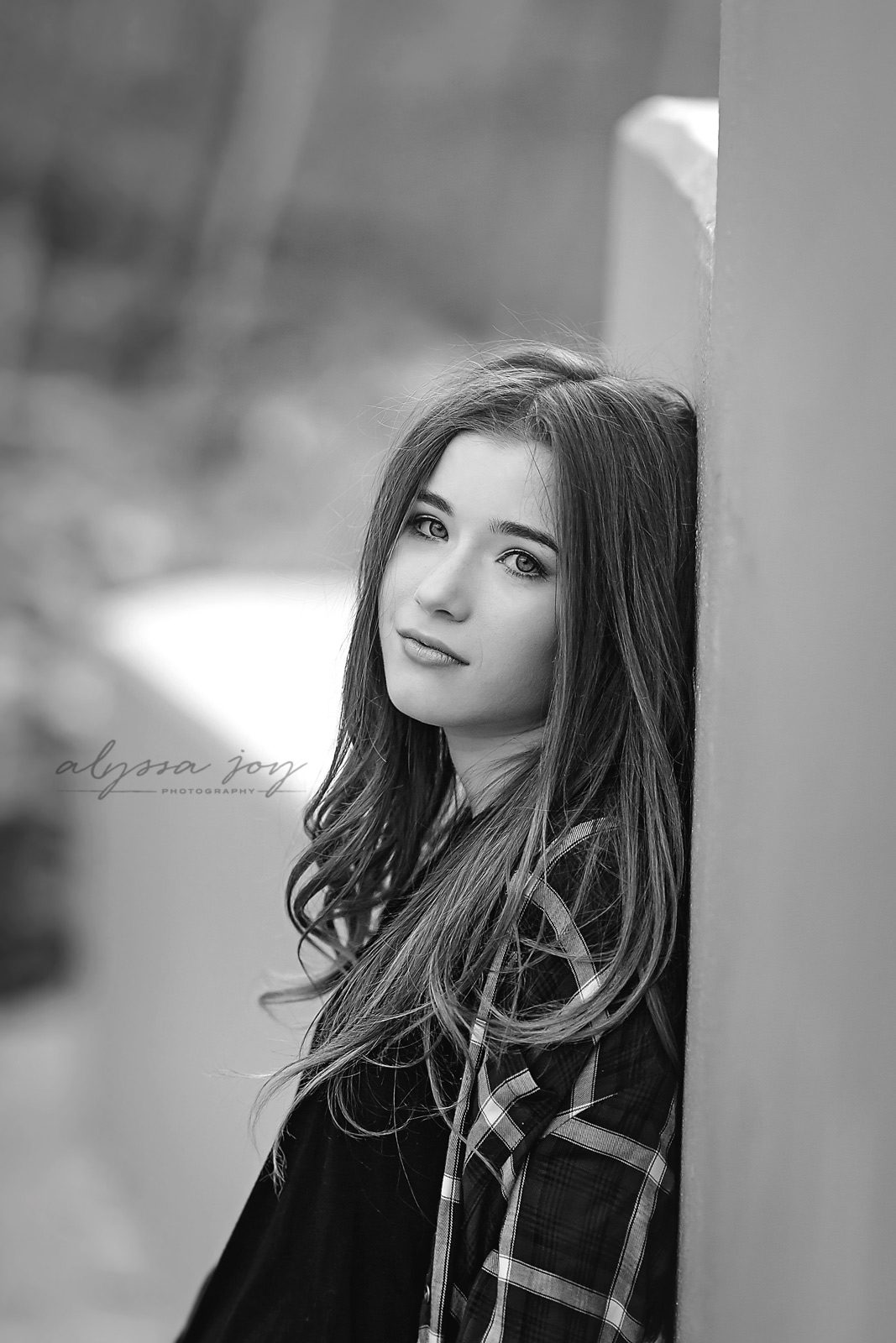 black and white photo of teenage girl leaning against concrete wall by Alyssa Joy Photography