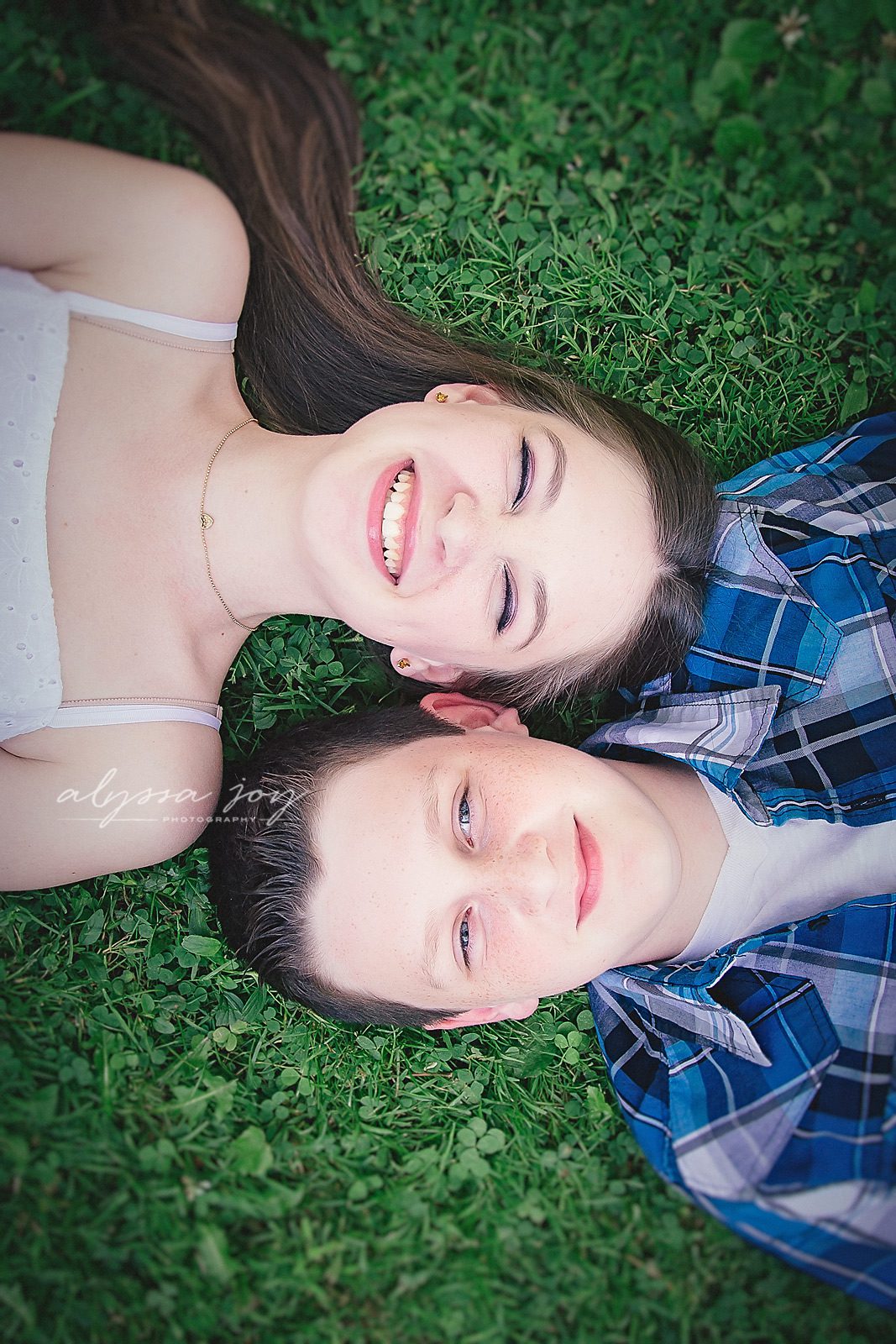 overhead image of brother and sister laughing in grass at park by Alyssa Joy Photography