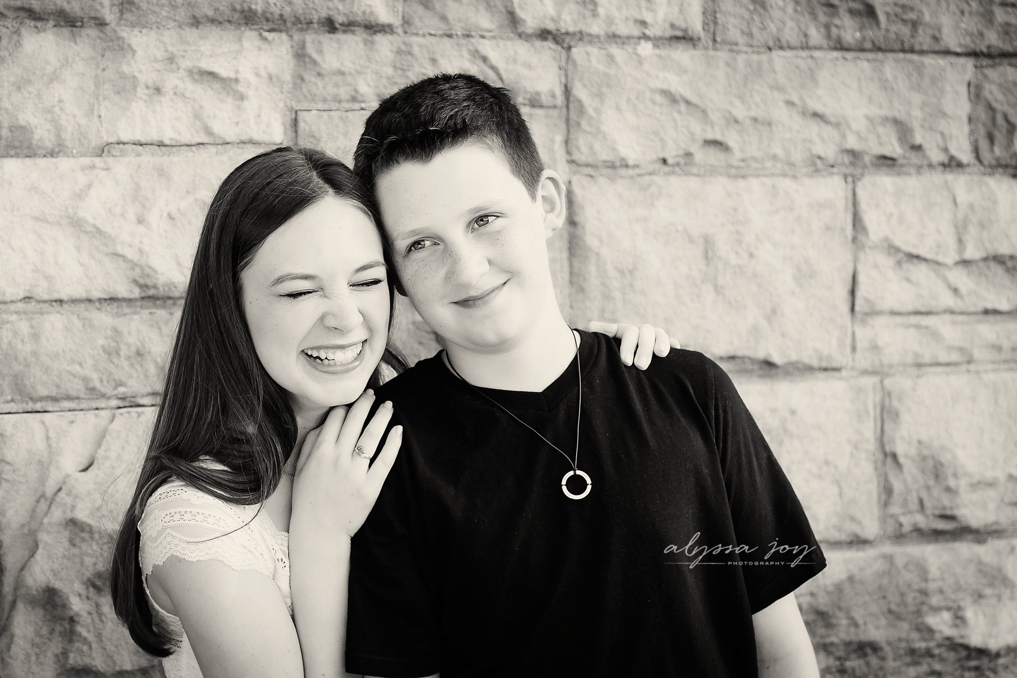 black and white picture of brother and sister smiling and hugging by Alyssa Joy Photography