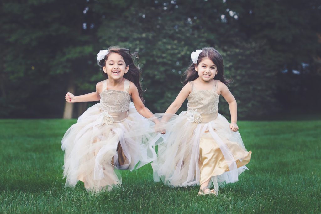 photo of two sisters in gorgeous dressings running and laughing captured by Alyssa Joy Photography