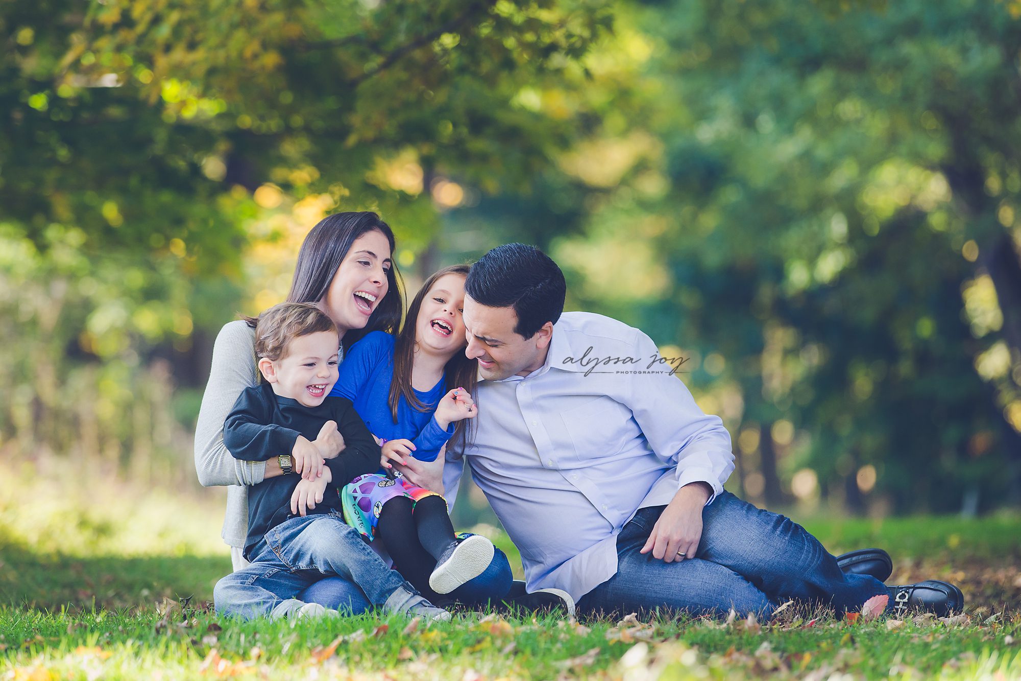 fun family of four fall photo session at park dressed in blue