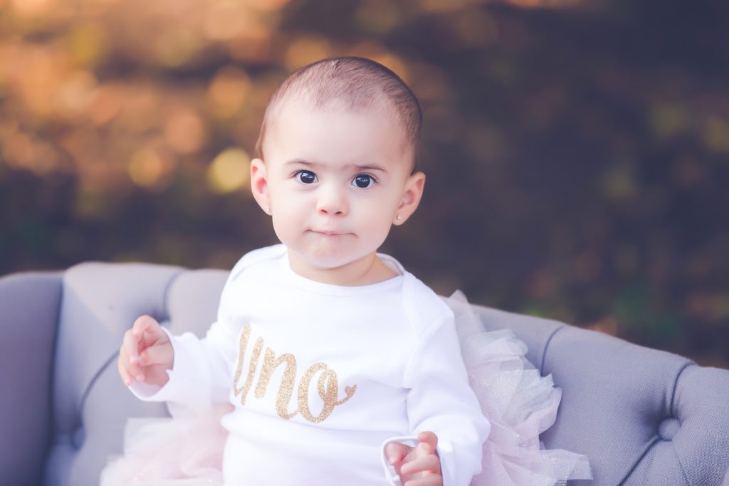 picture of little girl celebrating her first birthday wearing an "uno" shirt