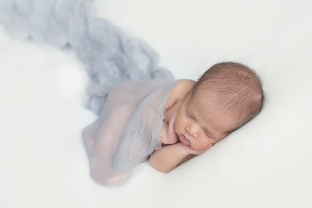 photo of newborn baby boy on white with light blue wrap Alyssa Joy Photography