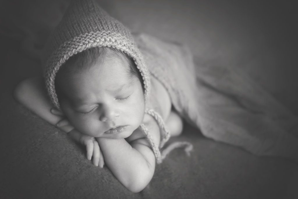 black and white photo of newborn baby boy with bonnet Alyssa Joy Photography