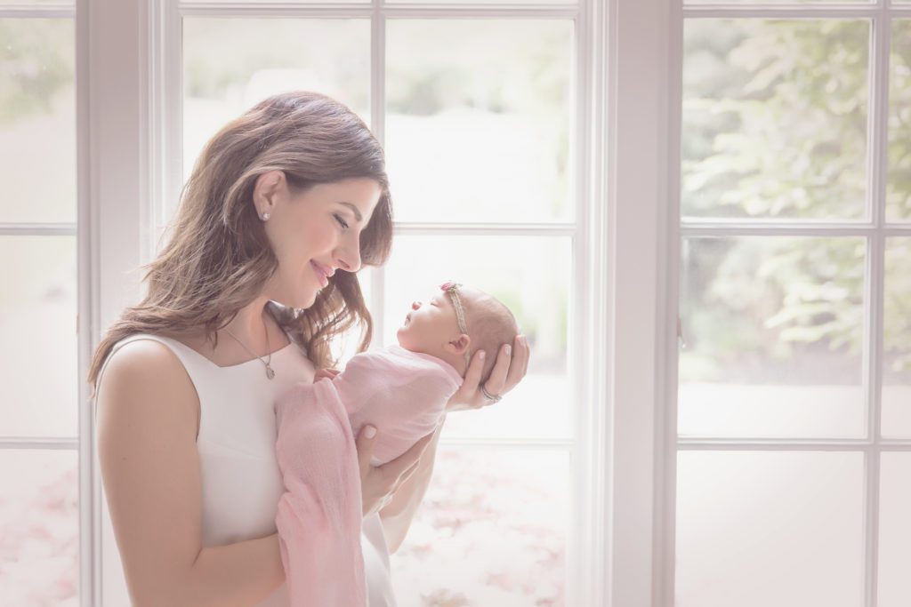 picture of mom holding newborn baby girl in her home at lifestyle newborn session Alyssa Joy Photography