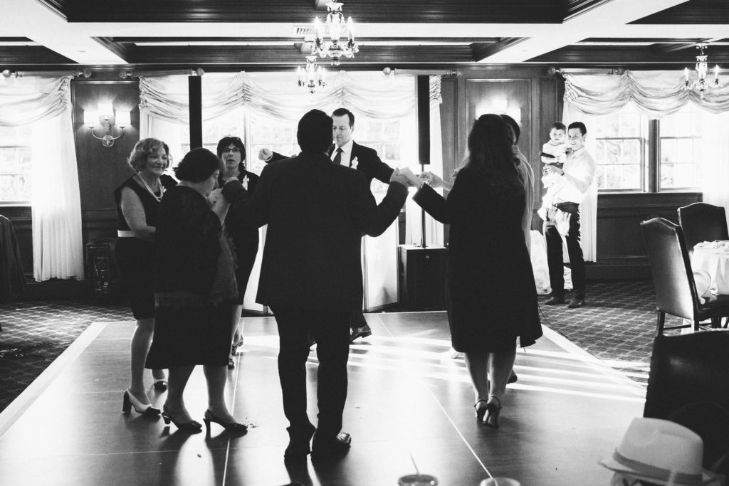 traditional greek dancing at baptism reception black and white