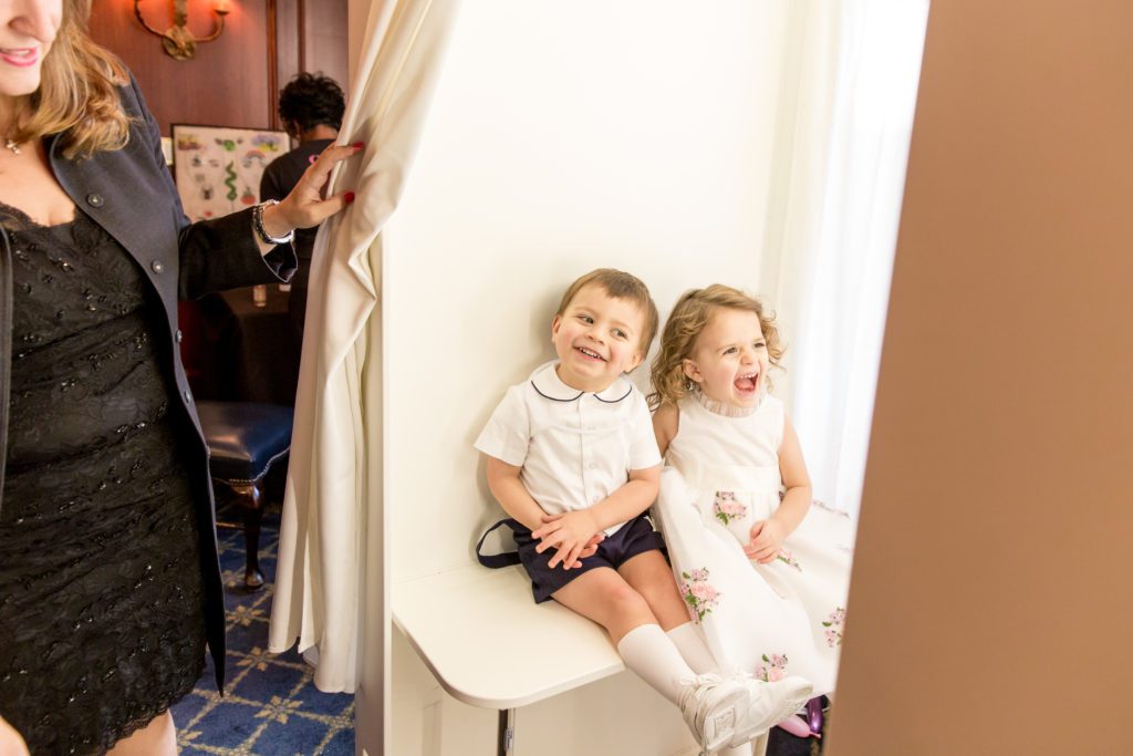 snapshot of two little kids enjoying the photo booth and baptism reception