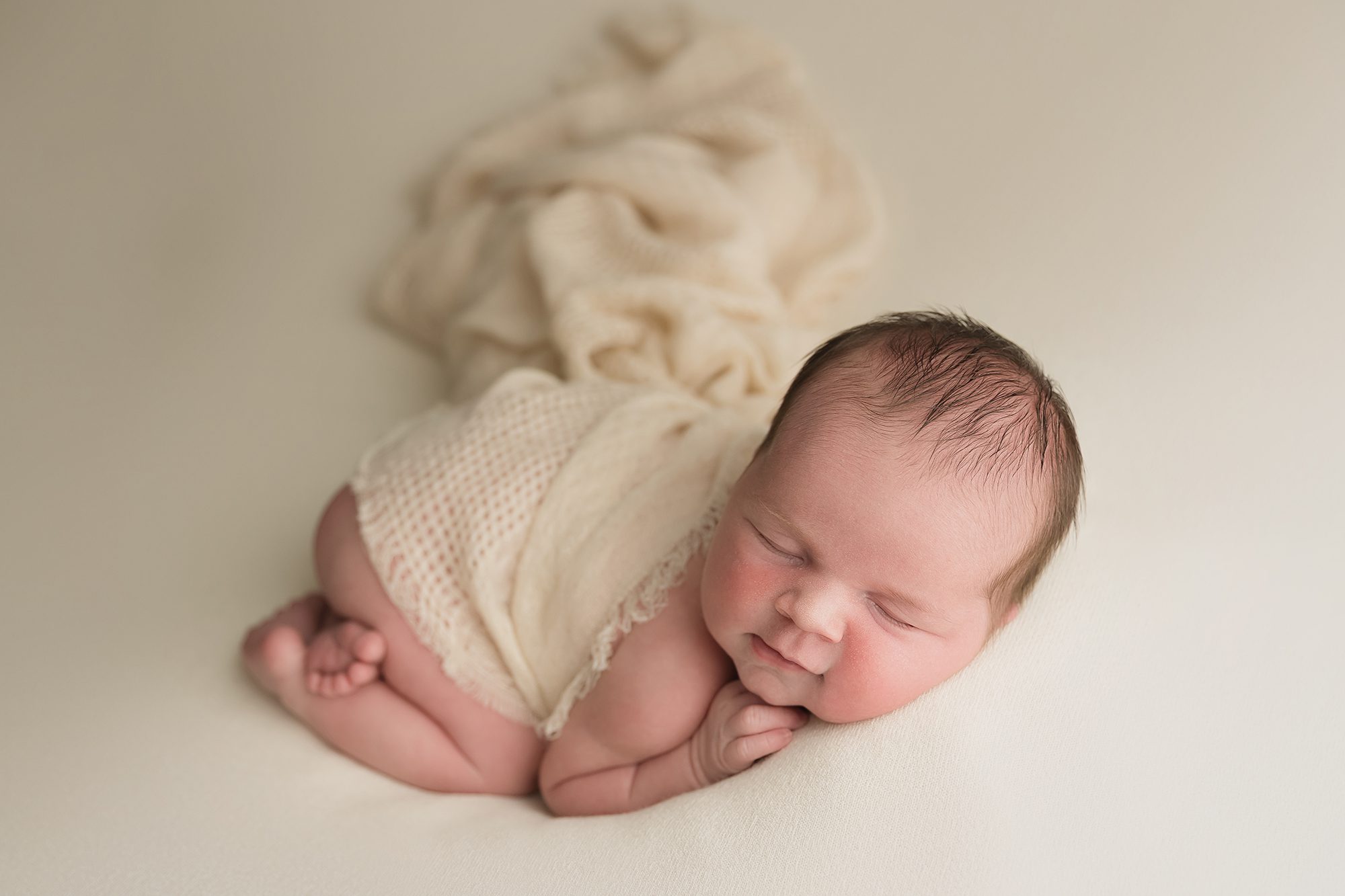 New Jersey Newborn Photographer. newborn baby girl on neutral fabric with flowing wrap