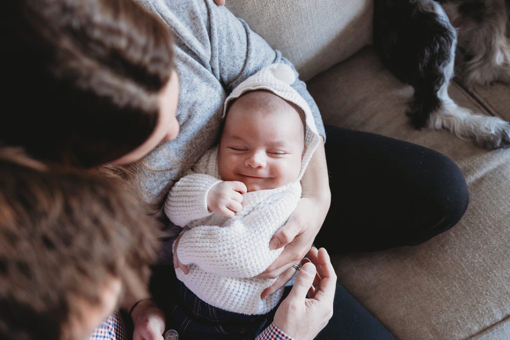 lifestyle newborn session parents holding smiling baby boy