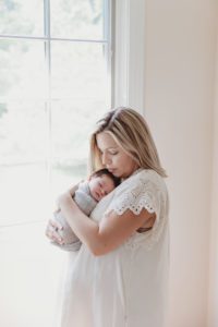 mom and newborn baby boy near window in lifestyle home session Alyssa Joy Photography